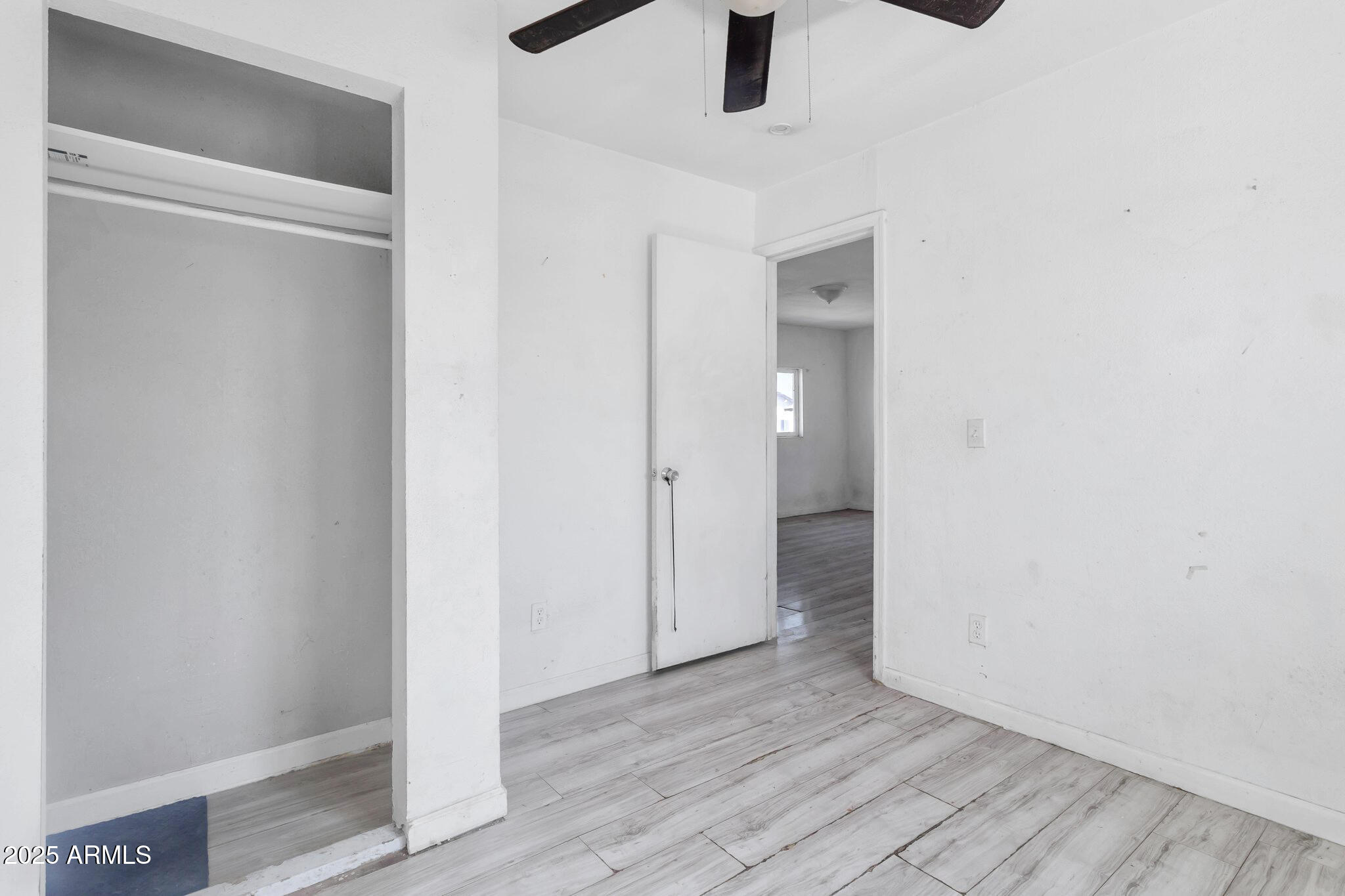 313 West Jones Avenue Phoenix, AZ 85041 - Photo 20 of 28 a view of an empty room with a window and wooden floor