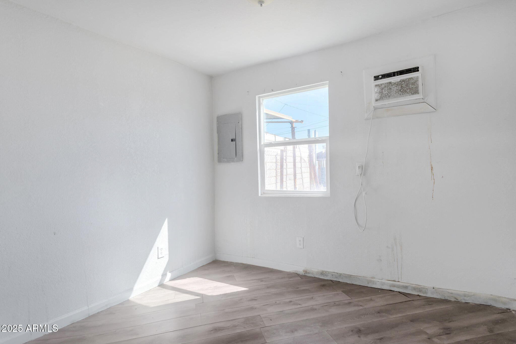 313 West Jones Avenue Phoenix, AZ 85041 - Photo 10 of 28 an empty room with wooden floor and windows