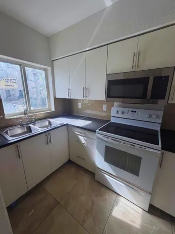 a kitchen with a sink stove and microwave