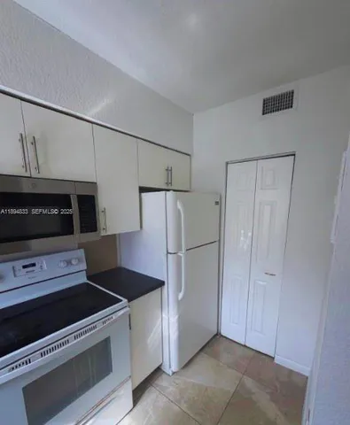a kitchen with stainless steel appliances a refrigerator and a stove top oven