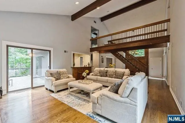 a view of a dining room and livingroom with furniture wooden floor a chandelier