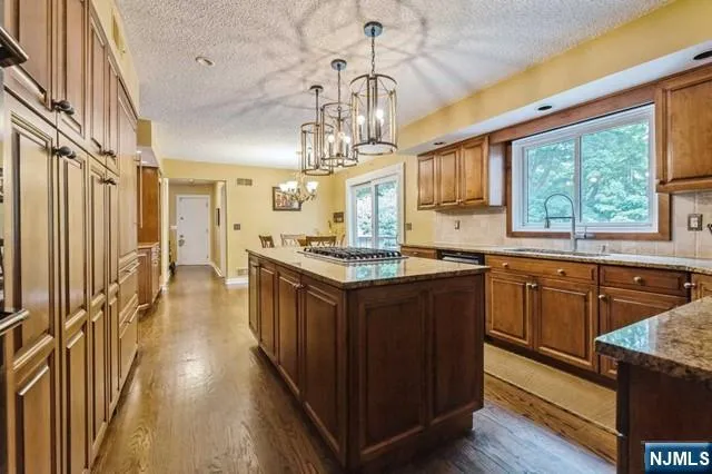 a bathroom with a granite countertop sink a toilet a mirror and shower