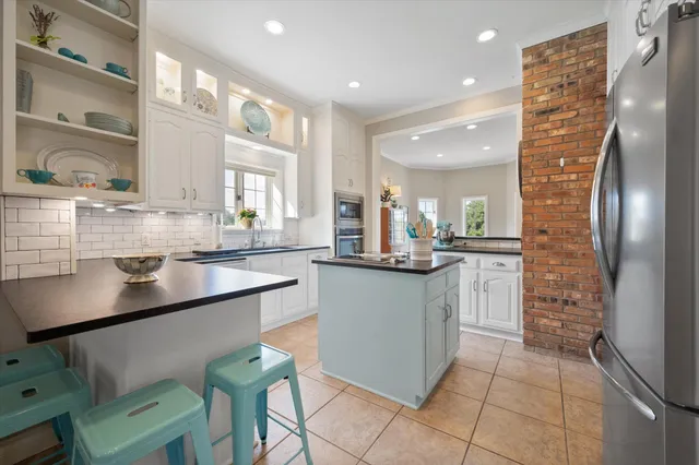 a kitchen with stainless steel appliances granite countertop a sink and a refrigerator