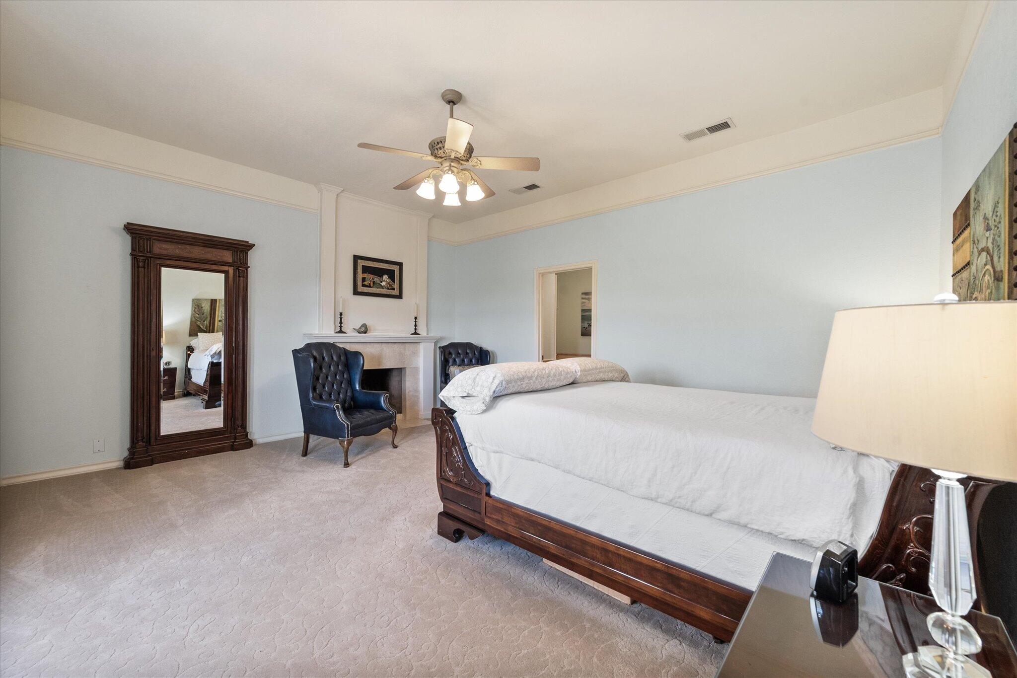67 South Lake Shore Drive Ransom Canyon, TX 79366 - Photo 32 of 52 a spacious bedroom with a bed and a lamp on table