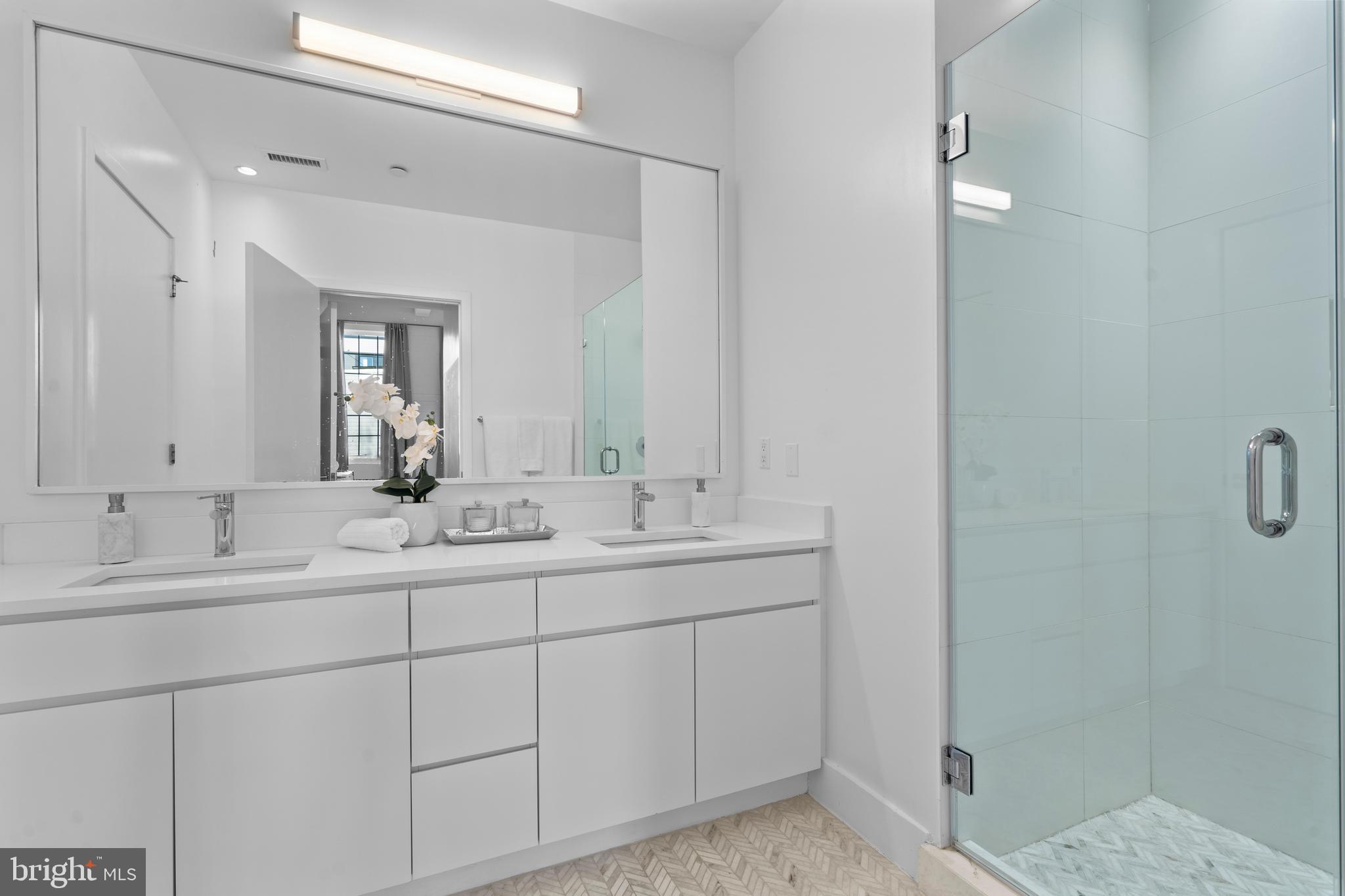 1324 E Street Southeast, Unit 201 Washington, DC 20003 - Photo 25 of 47 a bathroom with a double vanity sink and mirror