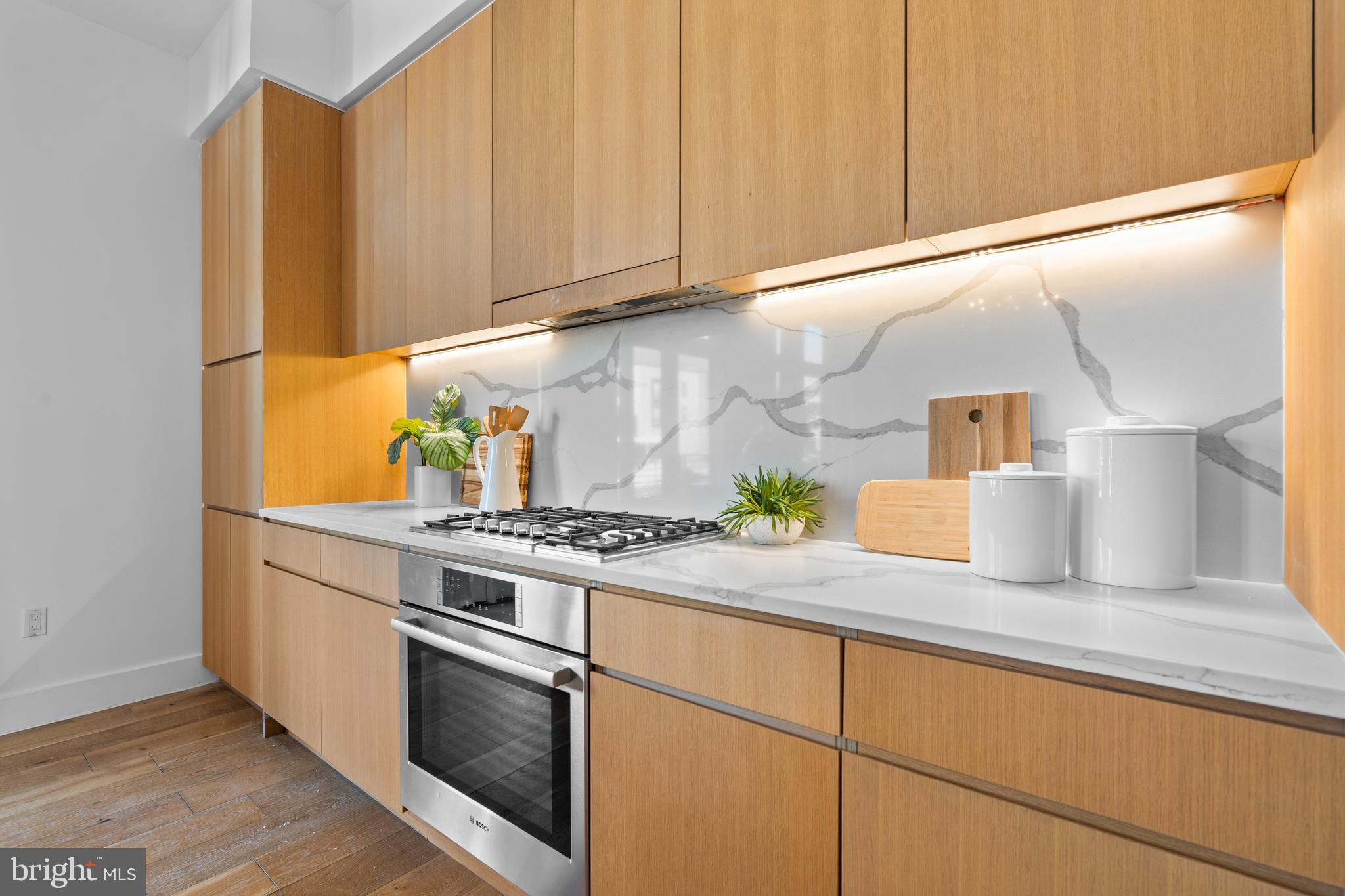1324 E Street Southeast, Unit 201 Washington, DC 20003 - Photo 9 of 47 a kitchen with granite countertop wooden cabinets and white appliances