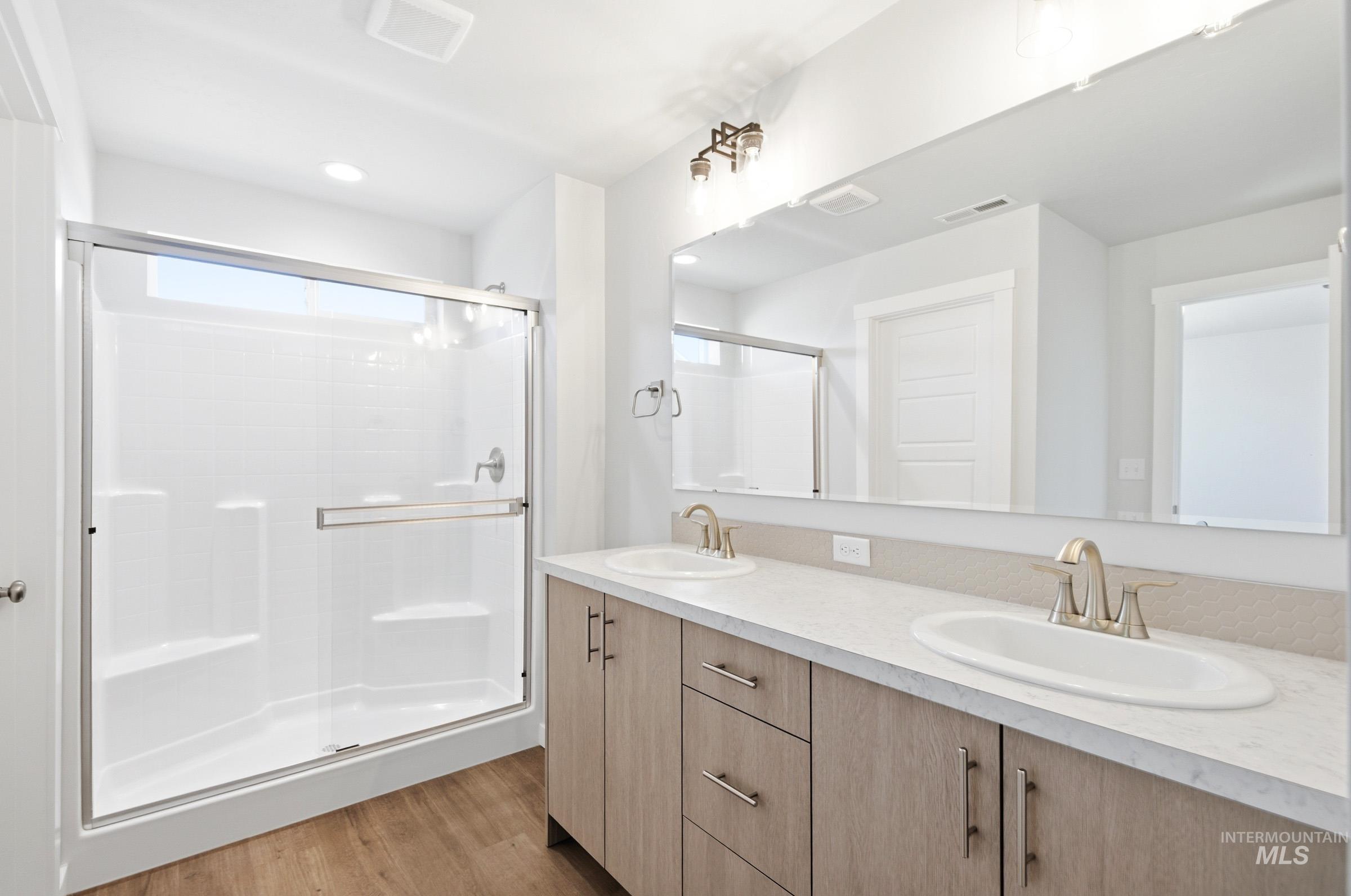 12877 Decatur Street Nampa, ID 83651 - Photo 22 of 22 Bathroom featuring a dual vanity with light wood-finish cabinetry, white countertop, and brushed nickel fixtures