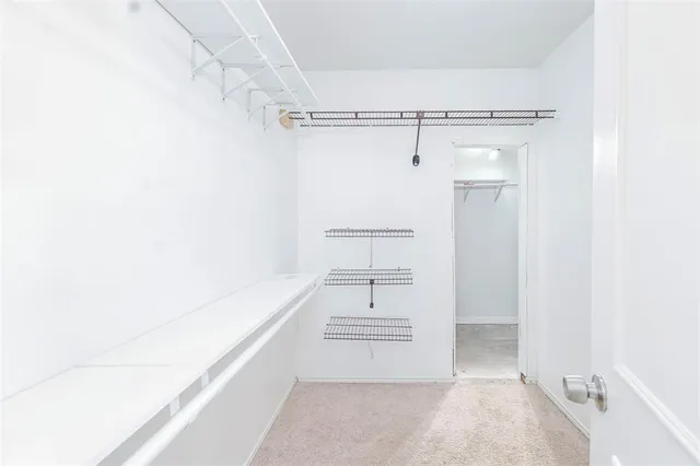 a view of walk in closet with empty racks