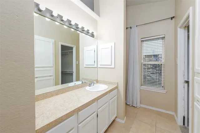 a bathroom with a granite countertop sink a large mirror and a shower