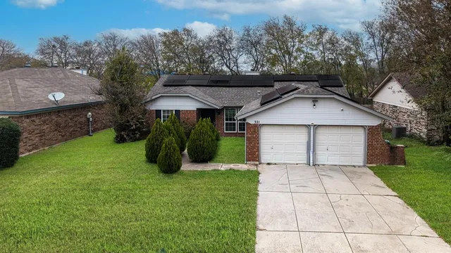 a view of a house with a yard and large tree