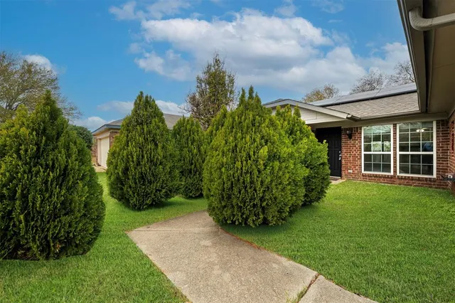 a view of a big house with a big yard and large tree