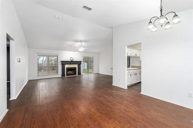 a view of a livingroom with wooden floor fireplace and window