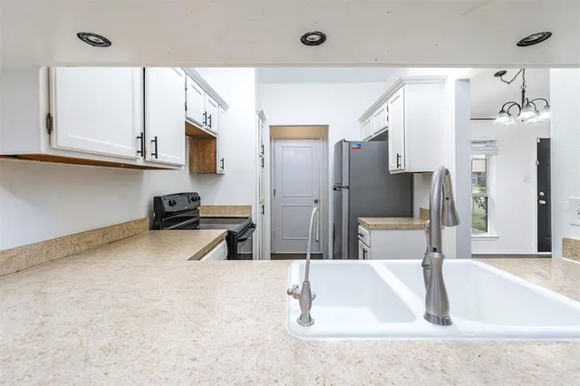 a kitchen with stainless steel appliances granite countertop a sink a stove and a refrigerator