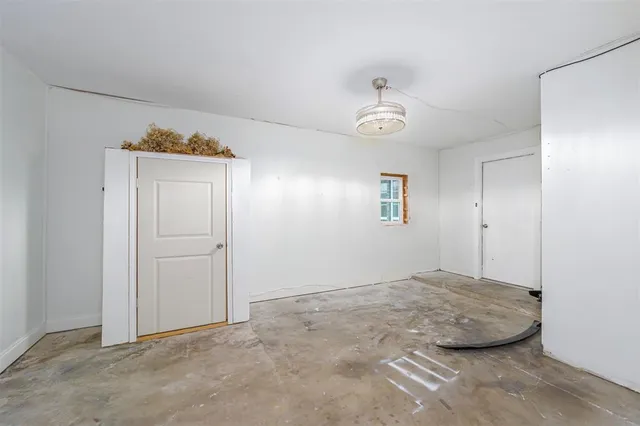 a view of an empty room and chandelier fan