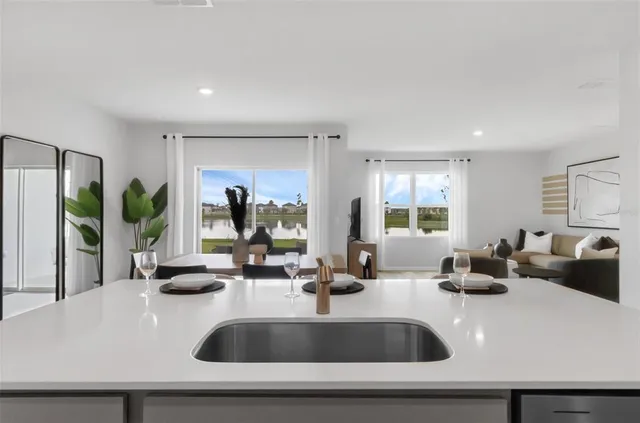 a kitchen with sink a large window and potted plant