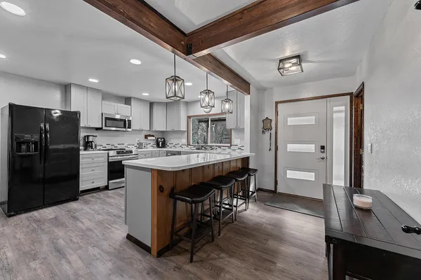 a kitchen with a refrigerator a sink dishwasher and a stove with wooden floor