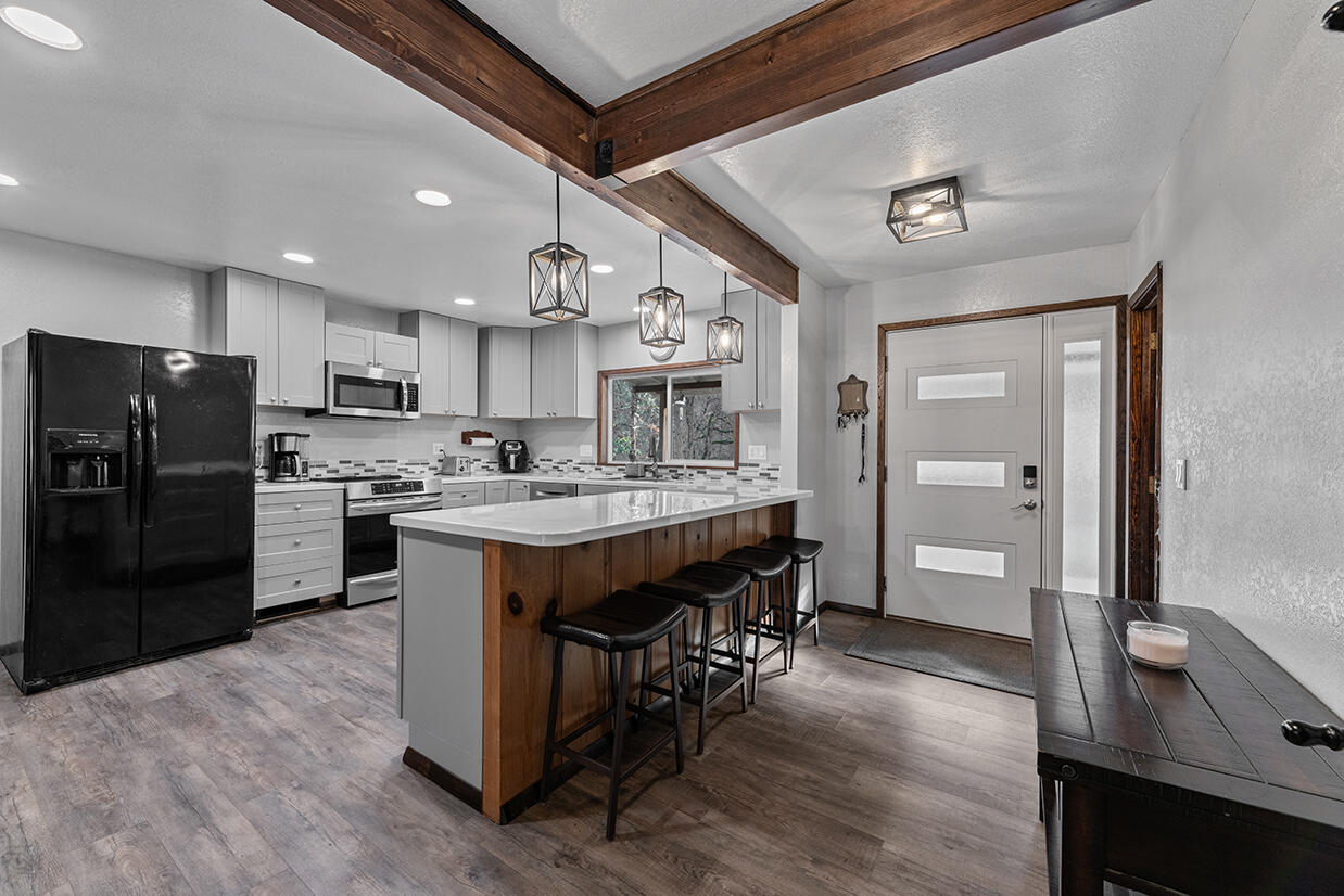 2900 Indian Creek Road Shady Cove, OR 97539 - Photo 1 of 35 a kitchen with a refrigerator a sink dishwasher and a stove with wooden floor