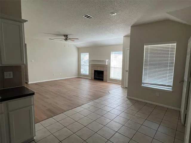 a view of a livingroom with a fireplace wooden floor and windows