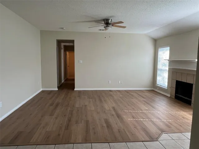a view of an empty room with a fireplace and a window