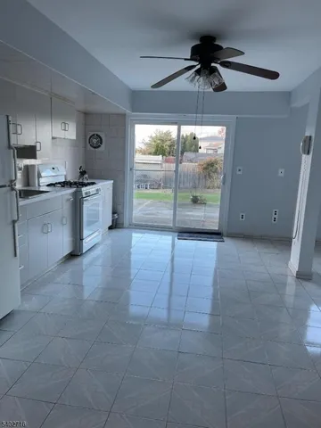 a large kitchen with granite countertop a stove a sink and a refrigerator