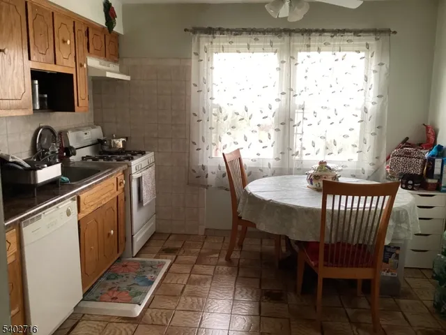 a kitchen with a dining table chairs and a stove