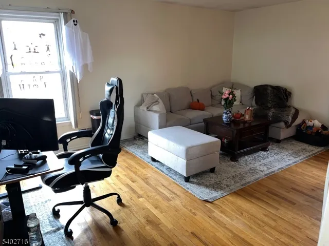 a living room with furniture a flat screen tv and a wooden floor