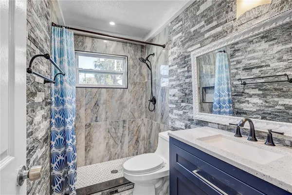 a bathroom with a sink and mirror with toilet