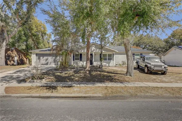 an aerial view of residential houses with outdoor space and trees