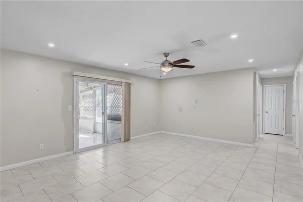 an empty room with fan and windows