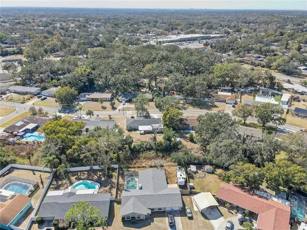 an aerial view of residential houses with outdoor space and trees