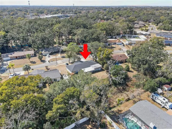 an aerial view of residential houses with outdoor space and trees
