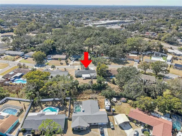 an aerial view of residential houses with city and green space