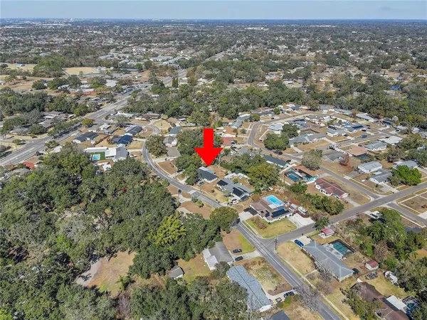 an aerial view of residential houses with outdoor space and trees
