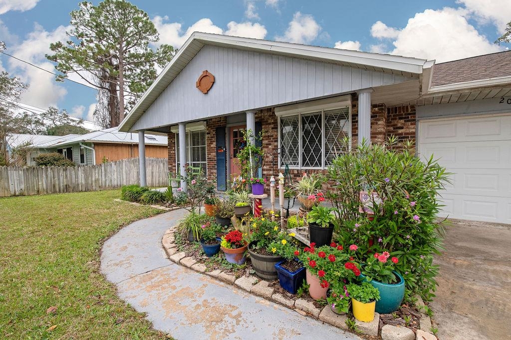 202 Argonaut Road St. Augustine, FL 32086 - Photo 3 of 33 a front view of a house with a yard and potted plants
