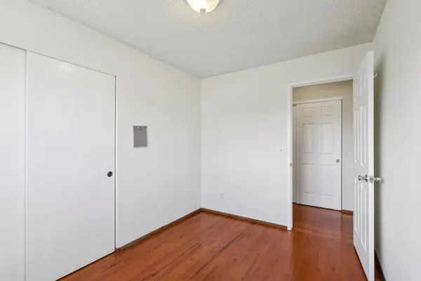 an empty room with wooden floor and closet