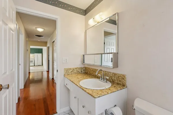 a bathroom with a granite countertop sink and a mirror