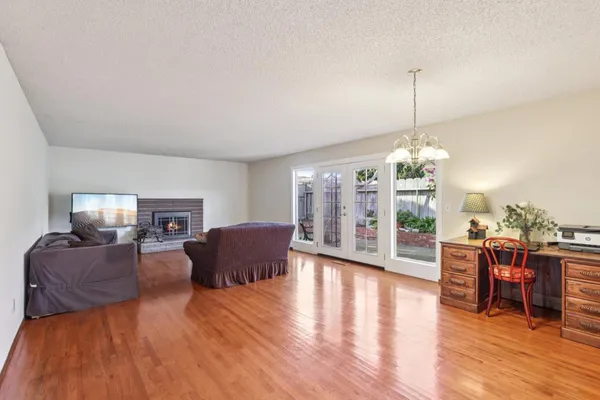 a living room with furniture chandelier and wooden floor