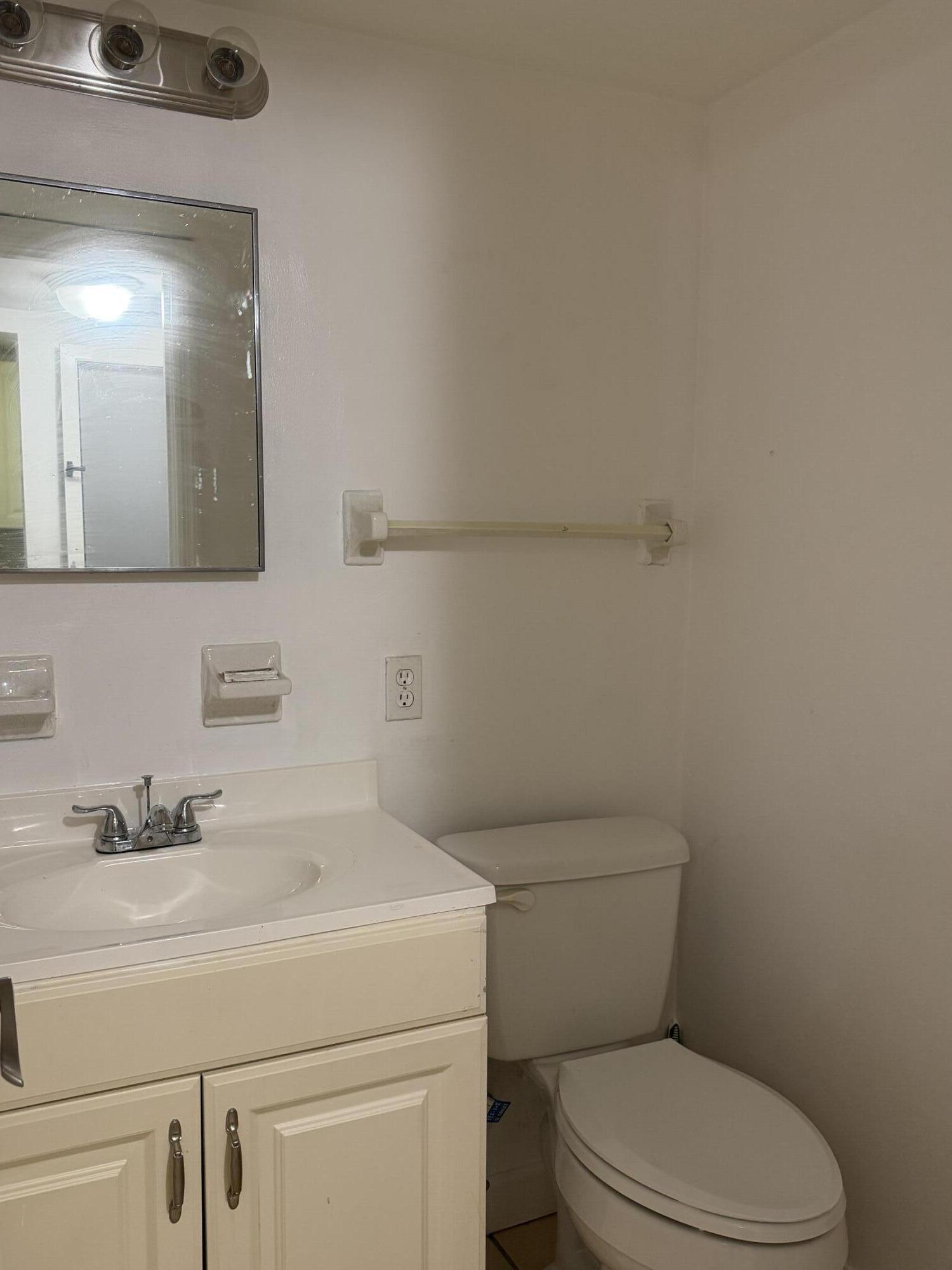 270 South Cypress Road, Unit 204 Pompano Beach, FL 33060 - Photo 12 of 14 a bathroom with a toilet sink and mirror