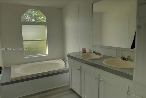 a bathroom with a tub sink and mirror
