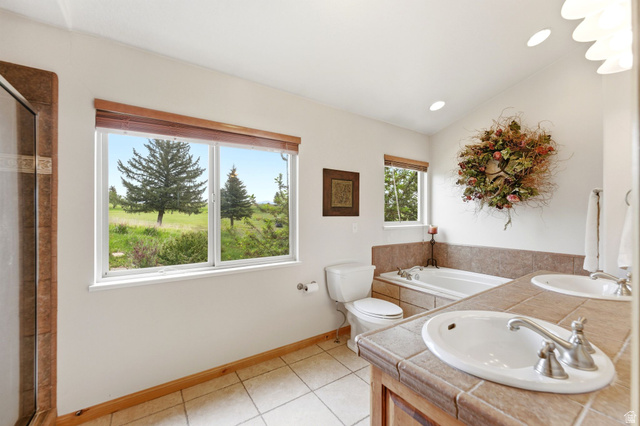 3634 North Huntsman Path, Unit C203 Eden, UT 84310 - Photo 10 of 27 Bathroom with dual windows, a tiled shower enclosure, and a built-in jetted tub