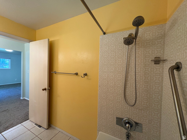 595 Meadowlark Road Orem, UT 84097 - Photo 30 of 87 Shower stall with patterned wall tiling, a dual shower head system, and a grab bar
