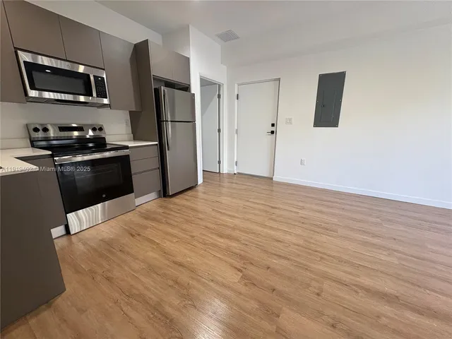 a kitchen with granite countertop a refrigerator stove and microwave
