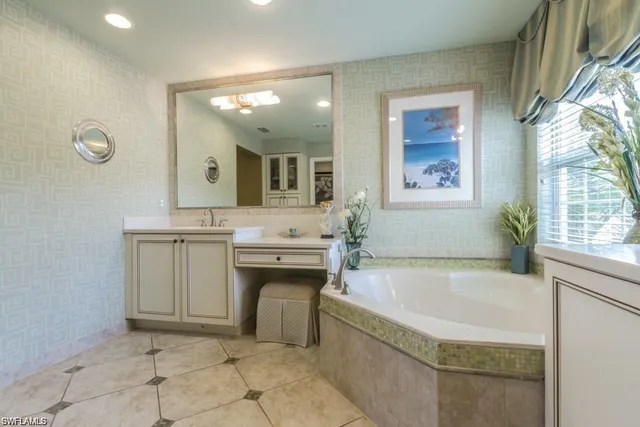 a spacious bathroom with a tub sink and mirror