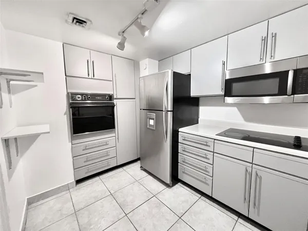 a kitchen with stainless steel appliances a refrigerator sink and cabinets