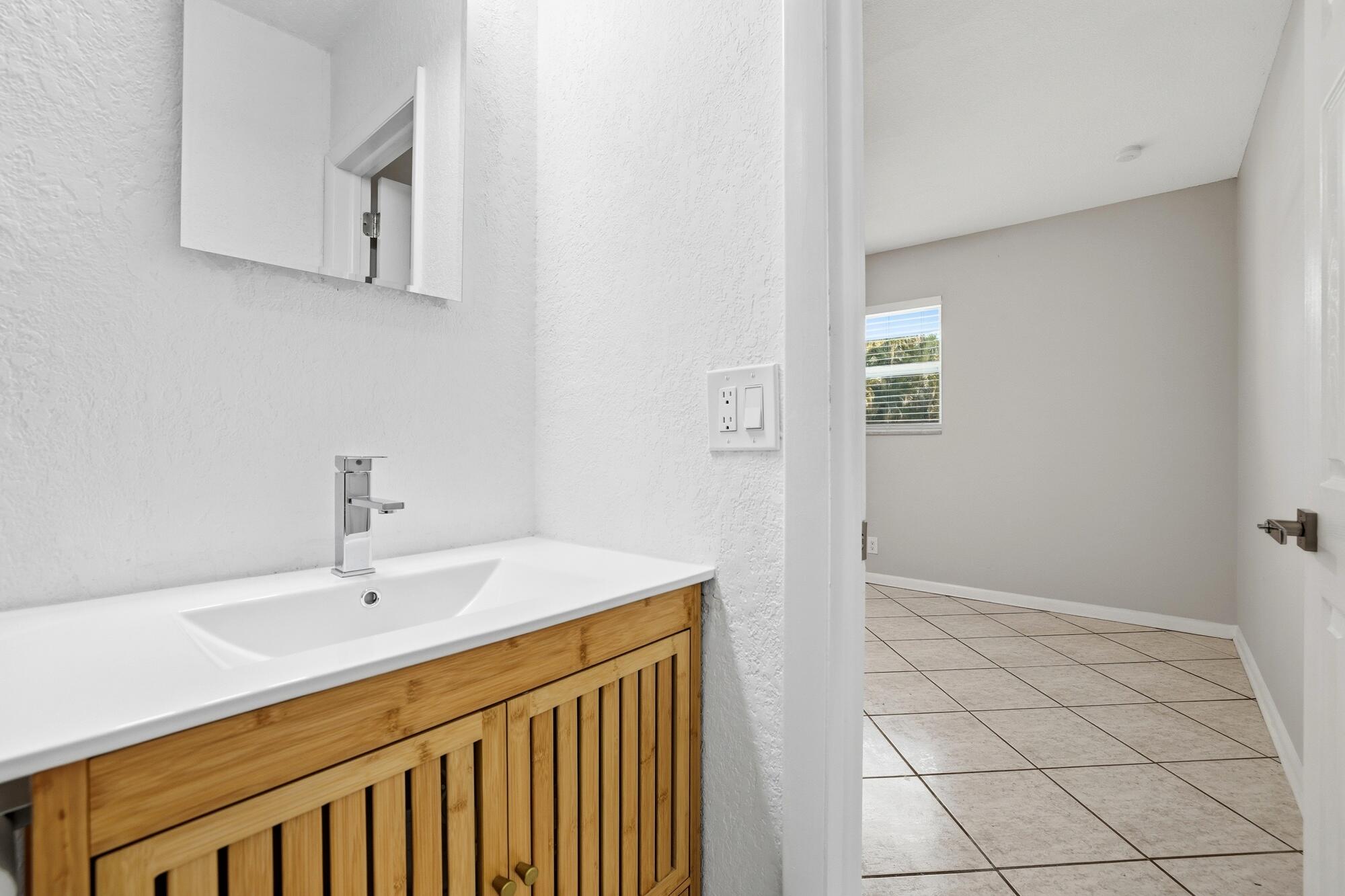 301 Wilma Circle Riviera Beach, FL 33404 - Photo 16 of 35 a bathroom with a sink and a mirror