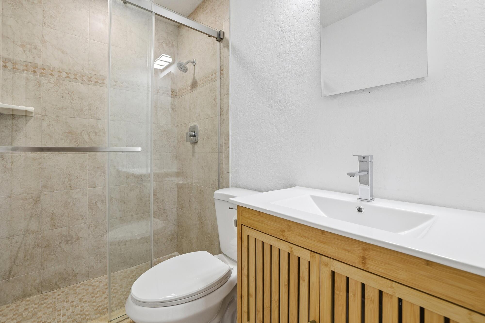 301 Wilma Circle Riviera Beach, FL 33404 - Photo 17 of 35 a bathroom with a sink a toilet and shower