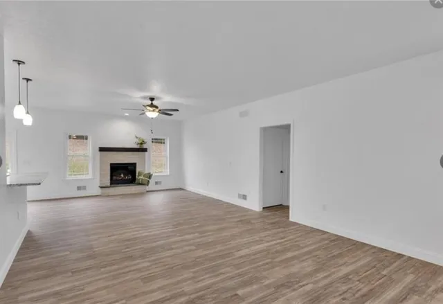 a view of a livingroom with a fireplace a ceiling fan and fireplace