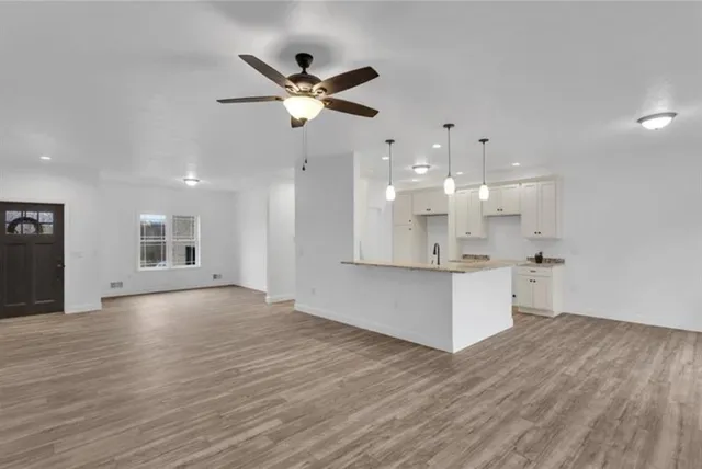 a view of an empty room with kitchen and kitchen view