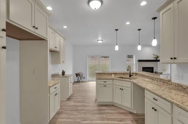 a large kitchen with stainless steel appliances kitchen island granite countertop a sink and cabinets