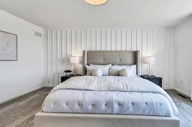 a large bed sitting in a bedroom next to a window